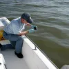 An environmental chemist collects samples of oil in the Gulf of Mexico from the Deepwater Horizon spill. The resulting chemical “fingerprint” of the oil will help determine the origin of other samples.