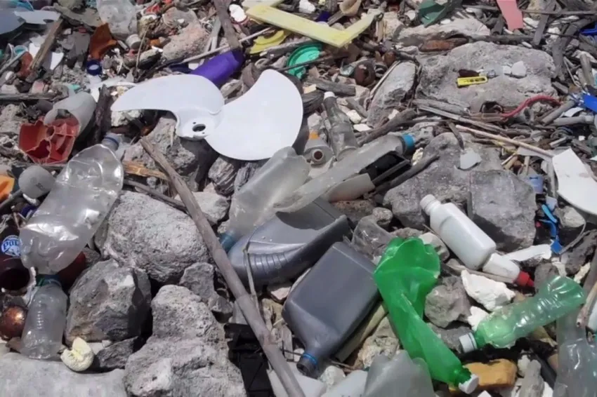 Plastic bottles and other marine debris cover a rocky beach in Curacao.
