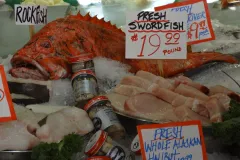 a rockfish and cut up swordfish displayed on ice