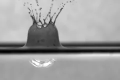 A raindrop falls into a surface oil slick treated with chemical dispersant.