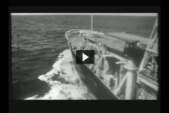 A screenshot from the video "Integrated Ocean Drilling Program" showing the front of a research vessel moving through water. 