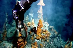 a robotic arm collects from a hydrothermal vent in the deep sea