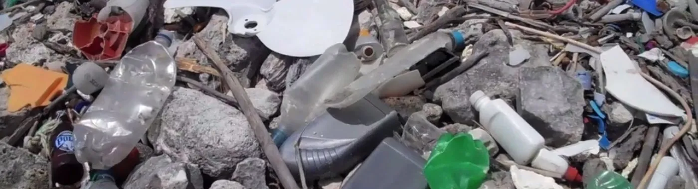 Plastic bottles and other marine debris cover a rocky beach in Curacao.